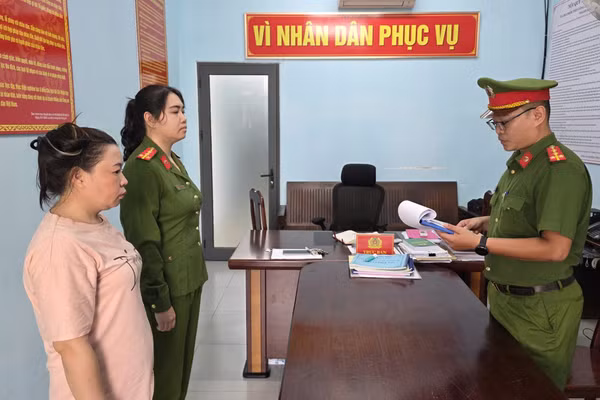 Công an tống đạt Quyết định tạm giữ và Lệnh bắt người bị giữ trong trường hợp khẩn cấp đối với Phạm Thị Hồng Phúc. Ảnh: Công an