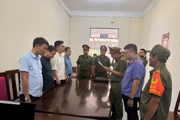 Cơ quan Công an tống đạt các quyết định khởi tố 4 bị can. (Ảnh: CACC)