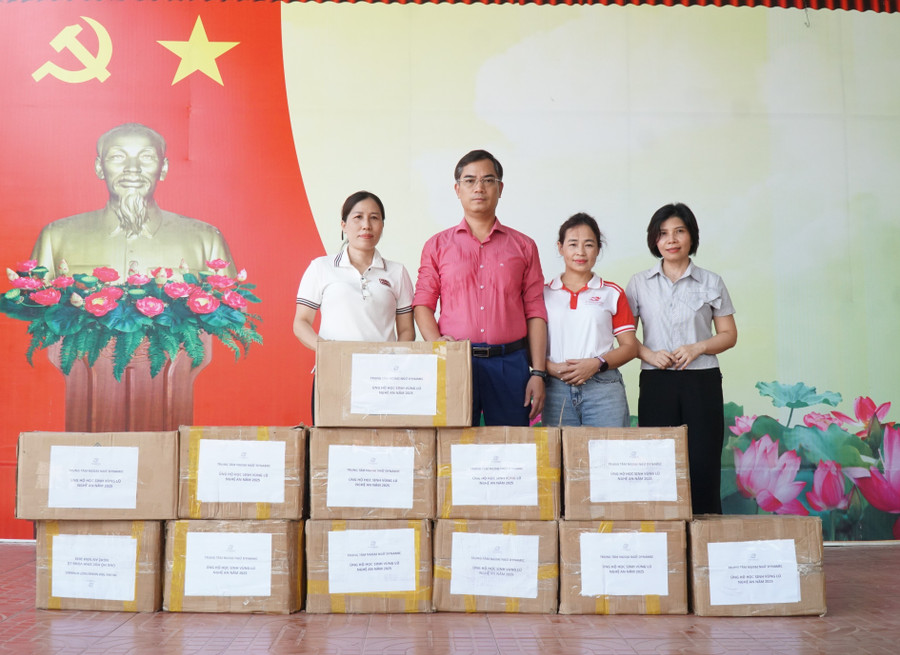 Đại diện Trung tâm Ngoại ngữ tại Nghệ An tặng sách vở cho học sinh Trường Tiểu học Thạch Giám (xã Tương Dương, Nghệ An). Ảnh: Hồ Lài so-gao-duc-trao-qua-9.jpg