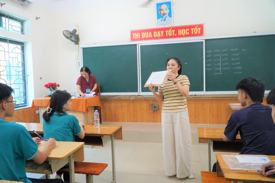 Giám thị giới thiệu túi đựng đề thi còn niêm phong và gọi thí sinh xác nhận. Ảnh: Hồ Lài thi-chuyen-phan-boi-chau-8.jpg