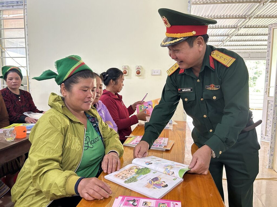 Cán bộ Đoàn Kinh tế - Quốc phòng 4 đến khích lệ, động viên học viên tham gia lớp xóa mù chữ. Ảnh: CSCC