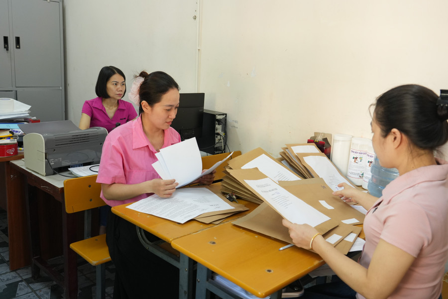 Cán bộ tuyển sinh Trường THPT Hà Huy Tập kiểm tra hồ sơ đăng ký dự thi của thí sinh. Ảnh: Hồ Lài thi-lop-10-nghe-an-4.jpg