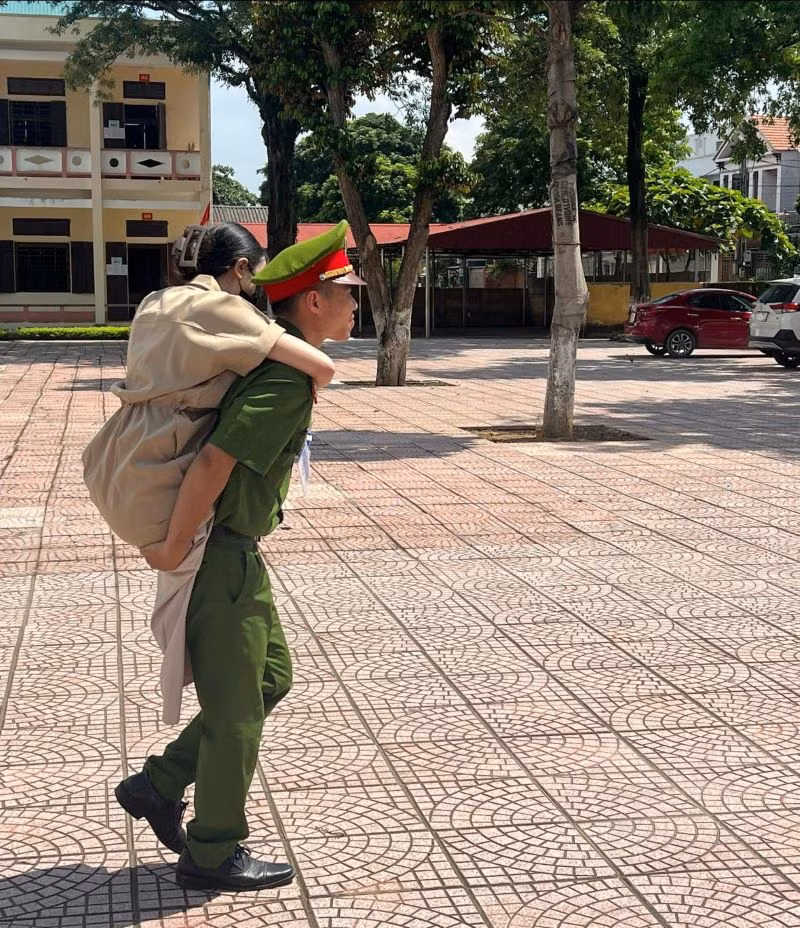 Trung uý Vũ Mạnh Cường - Cán bộ Đội điều tra tổng hợp, Công an huyện Thanh Thuỷ cõng thí sinh bị khuyết tật vào điểm thi trường THPT Trung Nghĩa, huyện Thanh Thuỷ (ảnh: Công an tỉnh Phú Thọ).