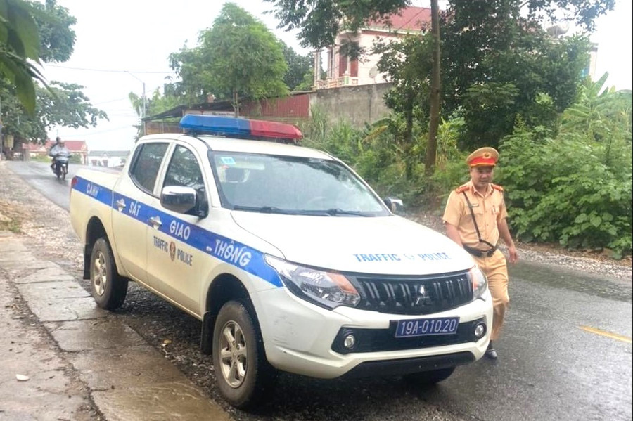 Cán bộ CSGT Công an huyện Thanh Sơn xuống xe hỏi thăm cháu Quang Hưng và người nhà (ảnh: Công an tỉnh Phú Thọ).