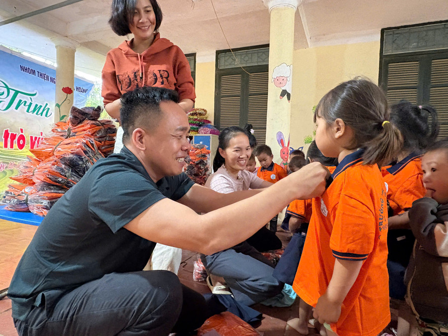 Nhà báo Nguyễn Minh Thịnh - Trưởng Văn phòng đại diện Báo Giáo dục và Thời đại khu vực Tây Bắc trao tặng áo đồng phục cho học sinh Trường Mầm non Sao Mai. tu-thien-1.jpg
