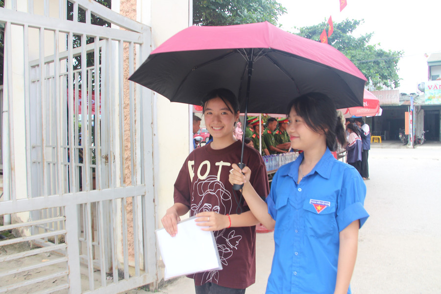 Tình nguyện viên che ô cho thí sinh. img-3982.jpg