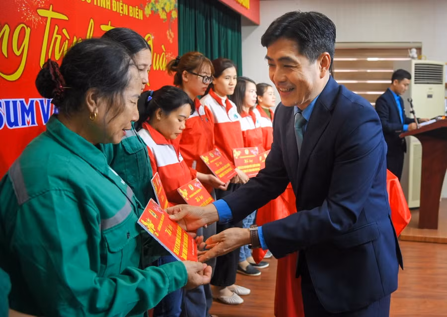 Ông Tẩn Minh Long, Chủ tịch LĐLĐ tỉnh Điện Biên, trao hỗ trợ vé xe cho người lao động. 