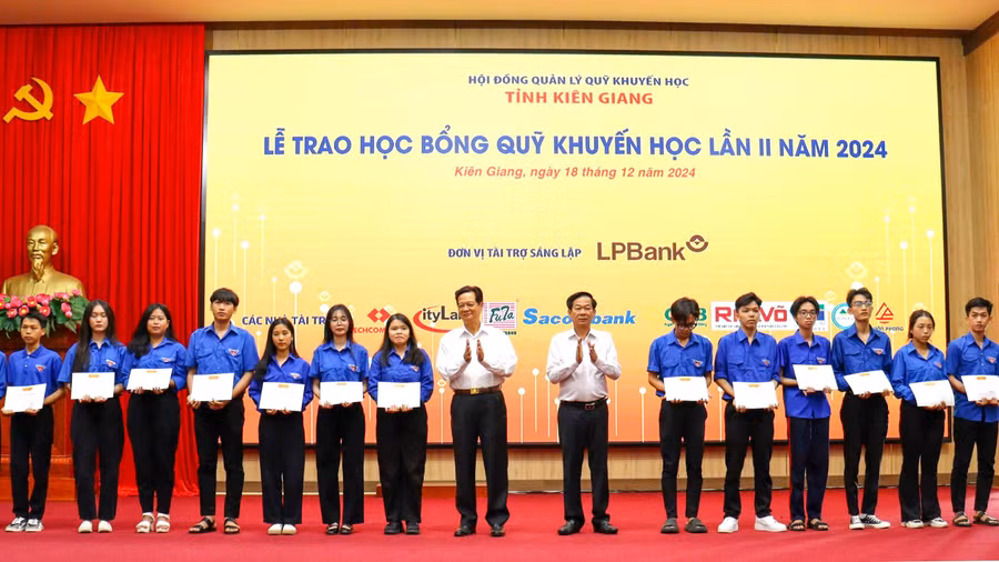 Nguyên Ủy viên Bộ Chính trị, Nguyên Thủ tướng Chính phủ Nguyễn Tấn Dũng và Bí thư Tỉnh ủy Đỗ Thanh Bình trao học bổng hỗ trợ cho sinh viên.