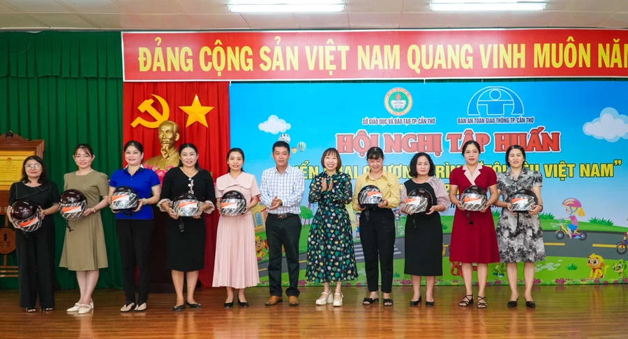 Lãnh đạo Sở GD&ĐT TP Cần Thơ và đại diện Ban ATGT TP Cần Thơ trao tặng mũ bảo hiểm cho các đại biểu.