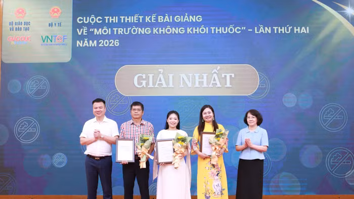 Nhà báo Triệu Ngọc Lâm và bà Phan Thị Hải trao giấy chứng nhận và hoa cho các tác giả đạt giải Nhất.