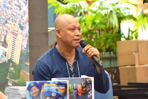 Nghệ sĩ nhiếp ảnh Nguyễn Á bên cạnh hai sách ảnh được ra mắt tại triển lãm. Ảnh: T.A.