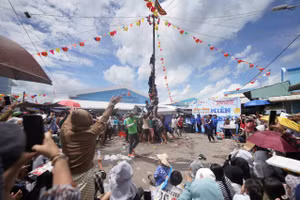 Trò chơi leo cây thoa mỡ bò luôn nhận được sự chú ý của đông đảo người dân lẫn du khách. Ảnh: Phạm Nguyễn