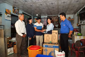 Đại diện doanh nghiệp và đoàn từ thiện trao quà cho hộ gia đình khó khăn tại xã Quảng Điền. 