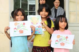 Các bé gái vùng cao hào hứng khoe tranh vẽ cùng các tình nguyện viên. Ảnh: DOP