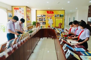 Các em học sinh tham quan và tìm hiểu các ấn phẩm sách trao tặng được trưng bày tại không gian văn hóa Hồ Chí Minh.