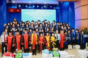 Các tân cử nhân chụp ảnh lưu niệm cùng thầy cô và Ban Giám hiệu nhà trường.