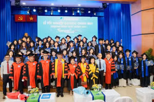 Các tân cử nhân chụp ảnh lưu niệm cùng thầy cô và Ban Giám hiệu nhà trường.