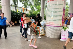 Thiếu nhi được cha mẹ đưa đến Nhà Thiếu nhi TPHCM để ủng hộ vật phẩm và góp sức cùng mọi người. Ảnh: NTNTP