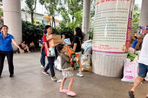 Thiếu nhi được cha mẹ đưa đến Nhà Thiếu nhi TPHCM để ủng hộ vật phẩm và góp sức cùng mọi người. Ảnh: NTNTP