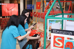 Nữ sinh trải nghiệm và quét ứng dụng Instagram để xem các tác phẩm nghệ thuật tích hợp thực tế ảo tăng cường tại Triển lãm "UEH & Saigon Culture". Ảnh: UEH