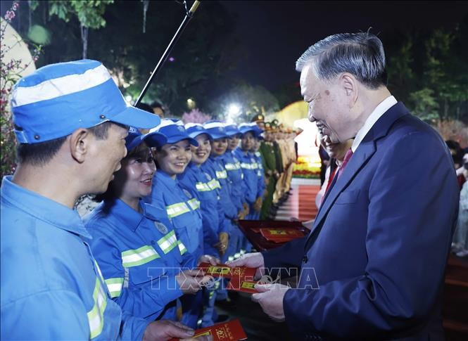 Tổng Bí thư Tô Lâm mừng tuổi cho công nhân môi trường đô thị tại khu vực vườn hoa Lý Thái Tổ. Ảnh: Thống Nhất/TTXVN