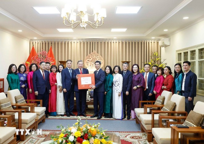 Tổng Bí thư Tô Lâm tặng quà cho cán bộ, nhân viên Khu Di tích Hoàng Thành Thăng Long-Hà Nội. (Ảnh: Thống Nhất/TTXVN)