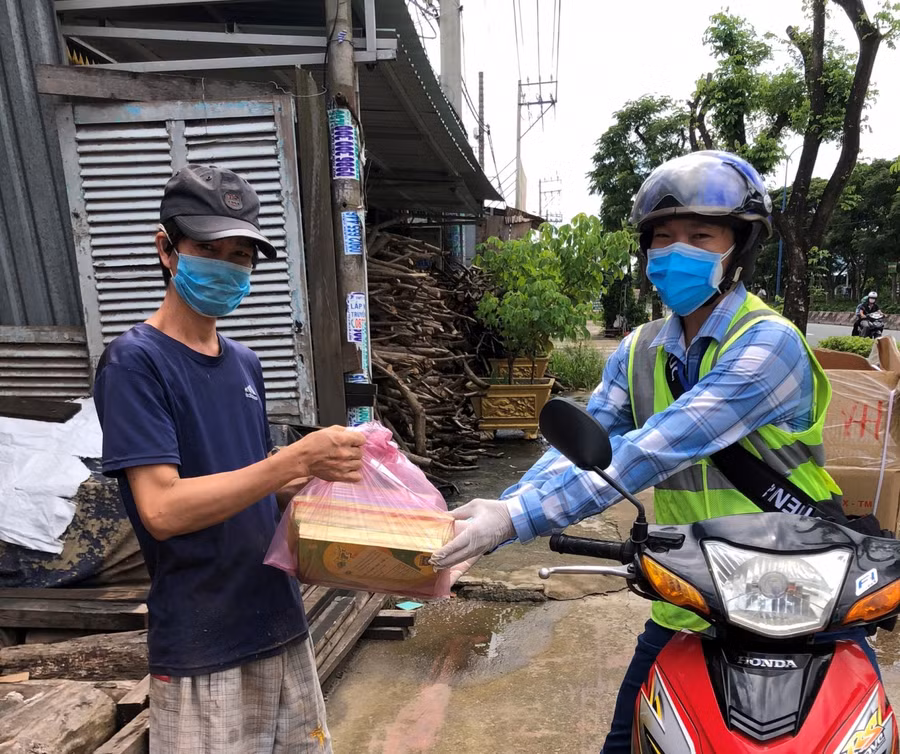 Thầy Lê Thanh Long (GV Trường Tiểu học Phạm Văn Hai, huyện B Chánh, TPHCM) giao SGK cho phụ huynh trên địa bàn huyện Bình Chánh.