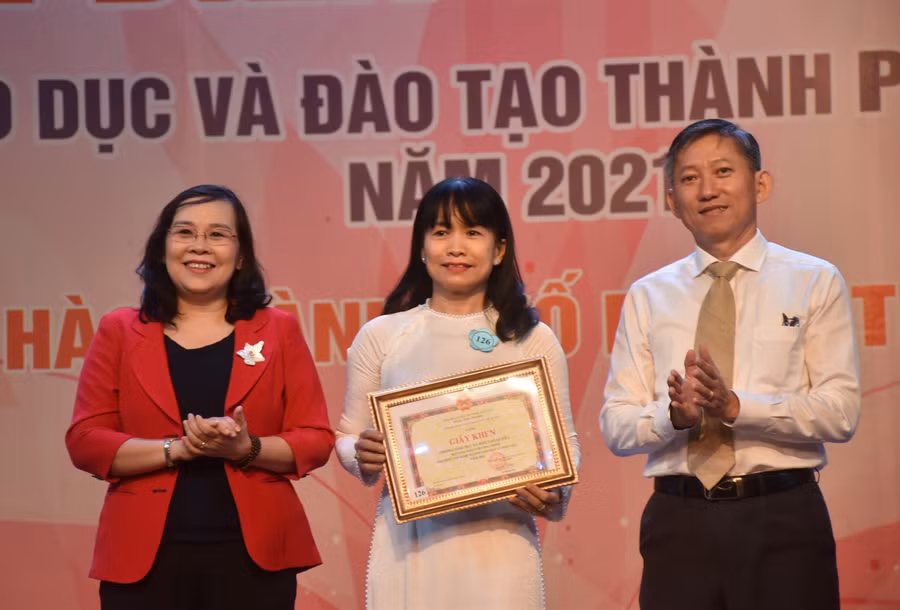 Ông Dương Trí Dũng (Phó Giám đốc Sở GD&amp;ĐT TPHCM - phải) và bà Huỳnh Thiện Nhi (Trưởng ban Tổ chức Quận ủy Quận 10 - trái) trao giải Nhất tập thể cho đại diện Phòng GD&amp;ĐT Quận 1. Ảnh: Công Chương.