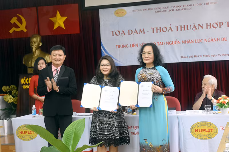 Đại diện HUFLIT ký kết thỏa thuận hợp tác với doanh nghiệp Victory travel tại sự kiện.
