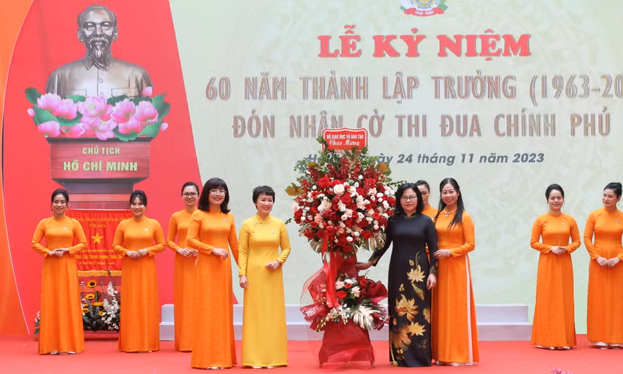 Thứ trưởng Ngô Thị Minh tặng hoa chúc mừng nhà trường.