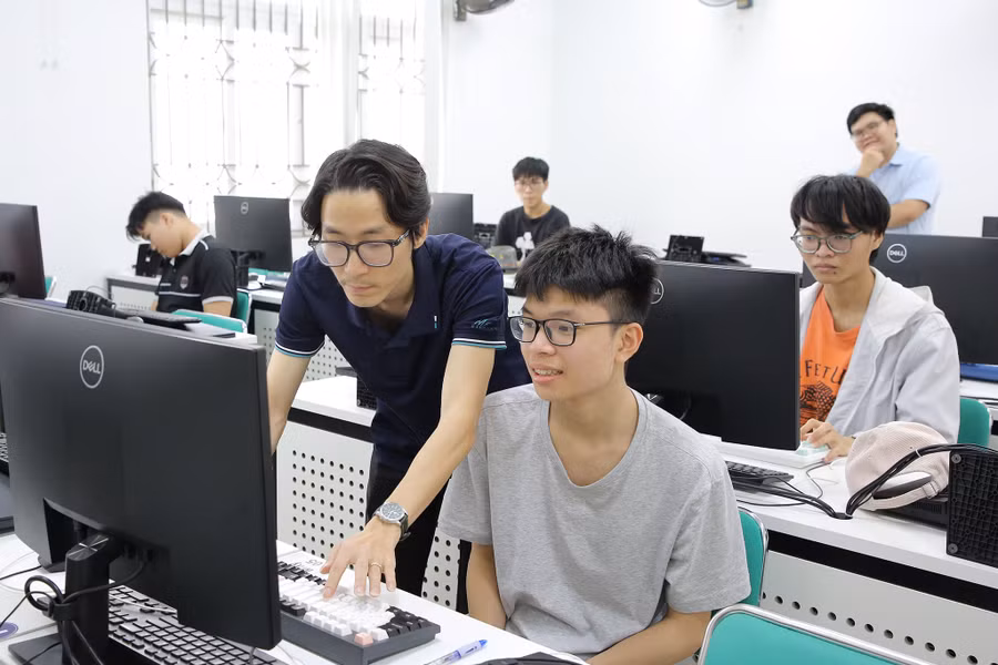 Chuyên viên Trường Đại học Công nghệ hỗ trợ thí sinh cài đặt phần mềm thi trực tuyến.