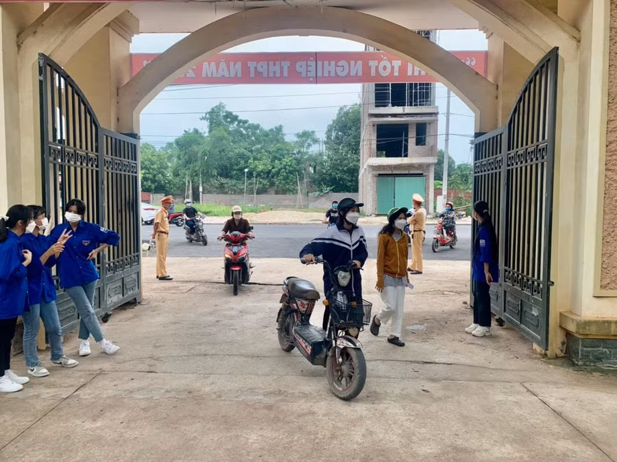 Tình nguyện viên tại Điểm thi trường THPT Tân Yên số 1 (huyện Tân Yên) hướng dẫn và động viên thí sinh đến làm thủ tục đăng ký dự thi chiều 6/7.