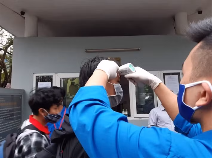 Thực hiện đo thân nhiệt, đeo khẩu trang khi ra vào Trường Đại học Điện lực.