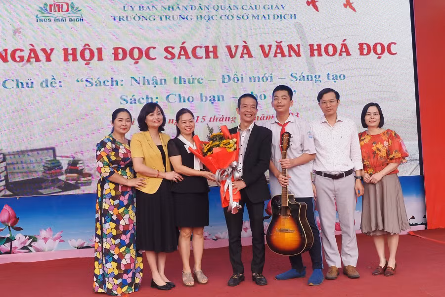 Ban Giám hiệu, hội cha mẹ học sinh trường THCS Mai Dịch tặng hoa, chụp ảnh lưu niệm với nhạc sĩ Nguyễn Vĩnh Tiến.