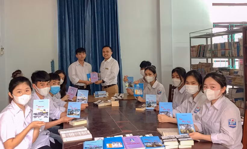 Thầy Vũ Đình Nghiệp - Hiệu trưởng trường THPT Mỏ Trạng trao tặng sách cho học sinh nhà trường.