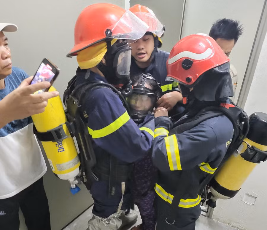 Cảnh sát hỗ trợ người dân ra khỏi đám cháy an toàn.