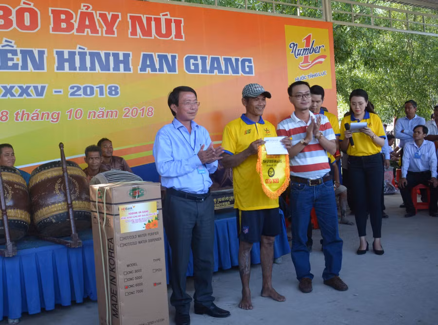 Ông Lê Nguyễn Đức Khôi, Trưởng phòng Quan hệ Công chúng, Tập đoàn Tân Hiệp Phát (bên phải) và Nhà báo Phạm Trung Lương, Phó giám đốc Đài Phát thanh Truyền hình An Giang trao giải Nhì cho ông Ngô Văn Cước ở xã Núi Voi, huyện Tịnh Biên, An Giang với số tiền thưởng 20 triệu đồng