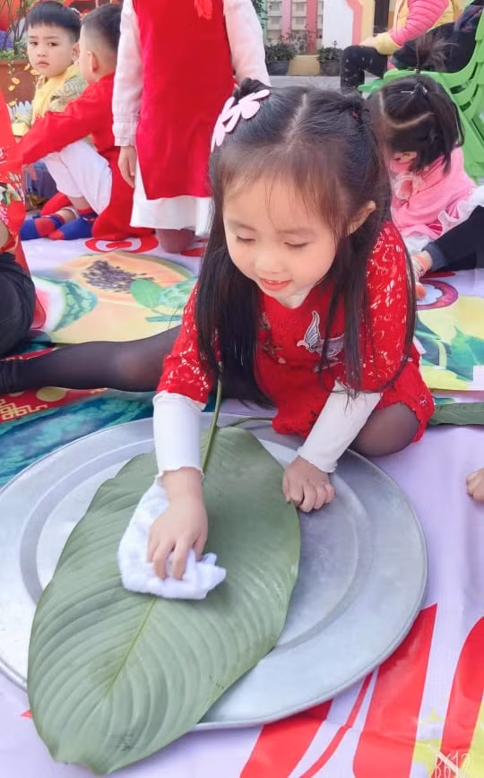 Trẻ mầm non với trải nghiệm gói bánh chưng ngày Tết.