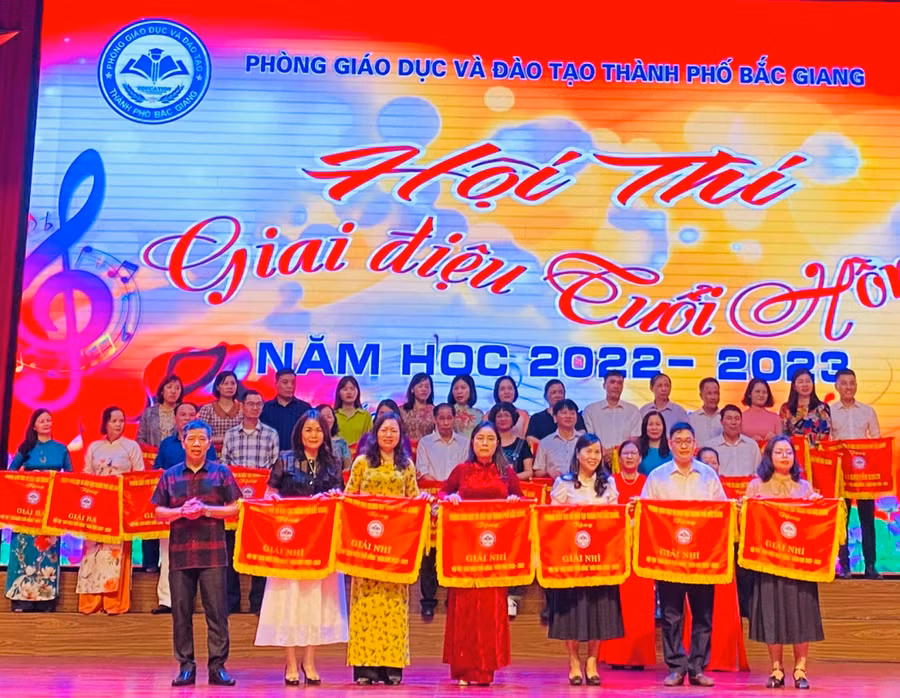 Nghệ sĩ Xuân Oánh, thành viên Hội nhạc sĩ Việt Nam - Trưởng ban giám khảo trao cờ cho các đơn vị đoạt giải Nhì.