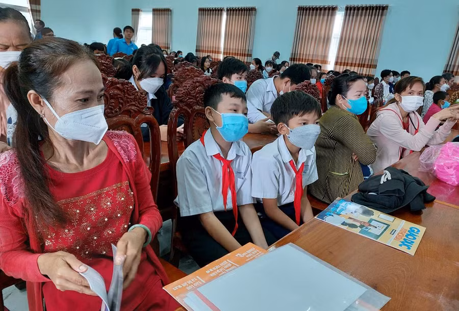 Chị Trần Thị Kiều Nương (bìa trái) đưa con tới nhận quà của chương trình.