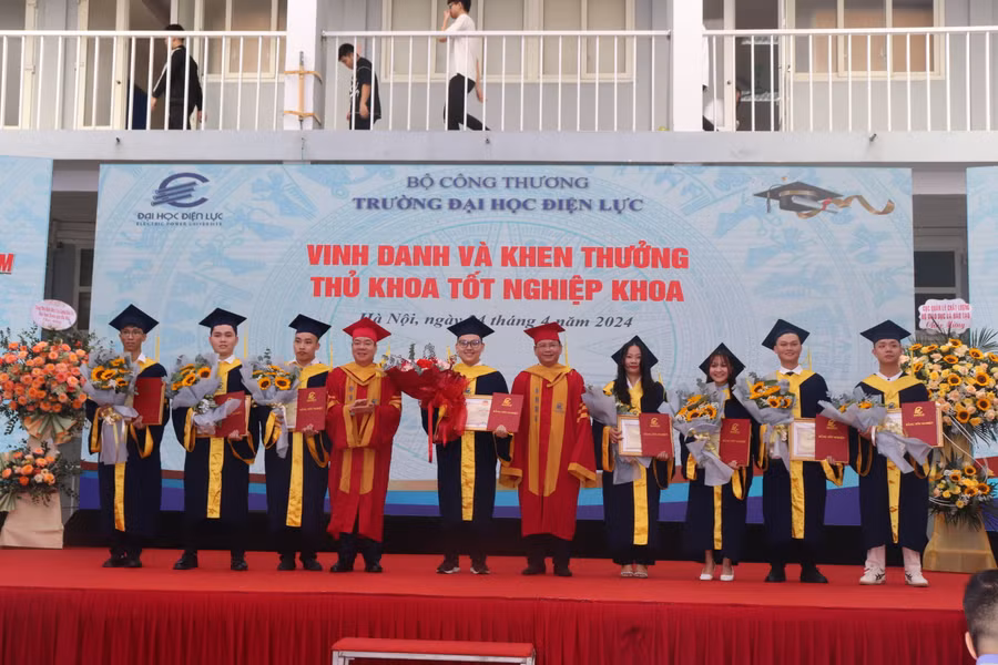 PGS.TS Vũ Đình Ngọ - Chủ tịch Hội đồng trường (bên trái) và PGS.TS Đinh Văn Châu - Hiệu trưởng trường Đại học Điện lực trao bằng tốt nghiệp và vinh danh thủ khoa tốt nghiệp khoa.