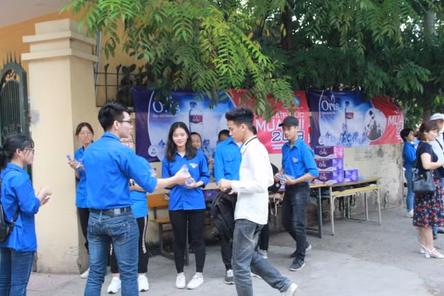 Thanh niên tình nguyện động viên, hướng dẫn sĩ tử vào phòng thi.