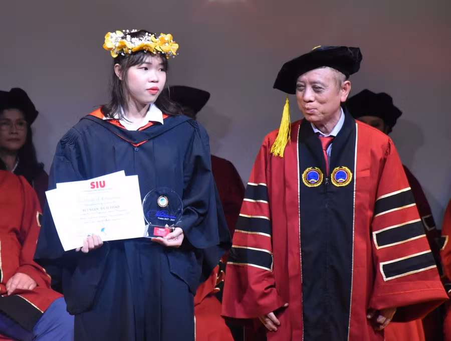 Bùi Ngọc Bích Thảo (trái) nhận tuyên dương từ lãnh đạo SIU tại lễ trao bằng tốt nghiệp (2/4).