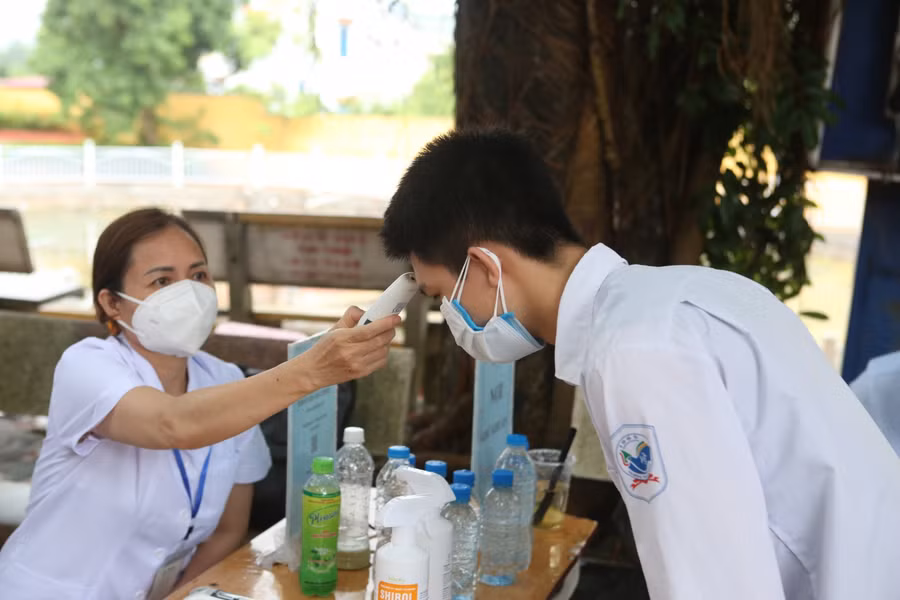 Thí sinh quên mang tờ khai y tế được kiểm tra đo thân nhiệt, nhắc nhở công tác phòng dịch.