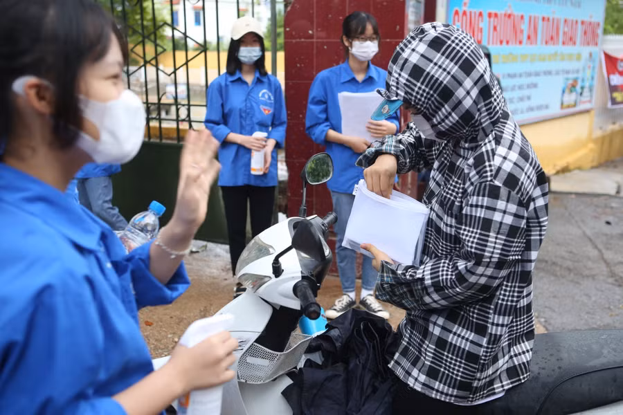 Thanh niên tình nguyện hỗ trợ, hướng dẫn thí sinh ngay tại cổng trường thi.