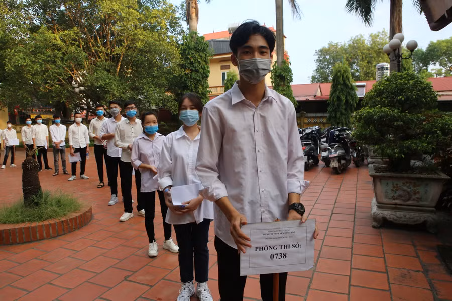 Thí sinh xếp thành từng hàng để đảm bảo giãn cách và di chuyển lên phòng thi.