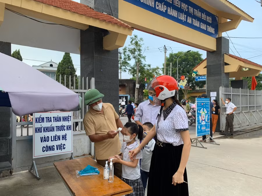 Học trường tiểu học thị trấn Đồi Ngô (huyện Lục Nam) được hướng dẫn thực hiện 5K đảm bảo an toàn phòng dịch ngay tại cổng trường.