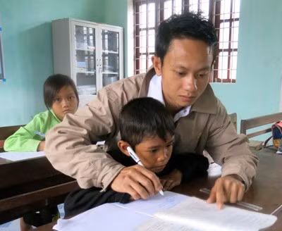 Thầy giáo Hồ Tiến Nam dạy chữ cho các em học sinh.