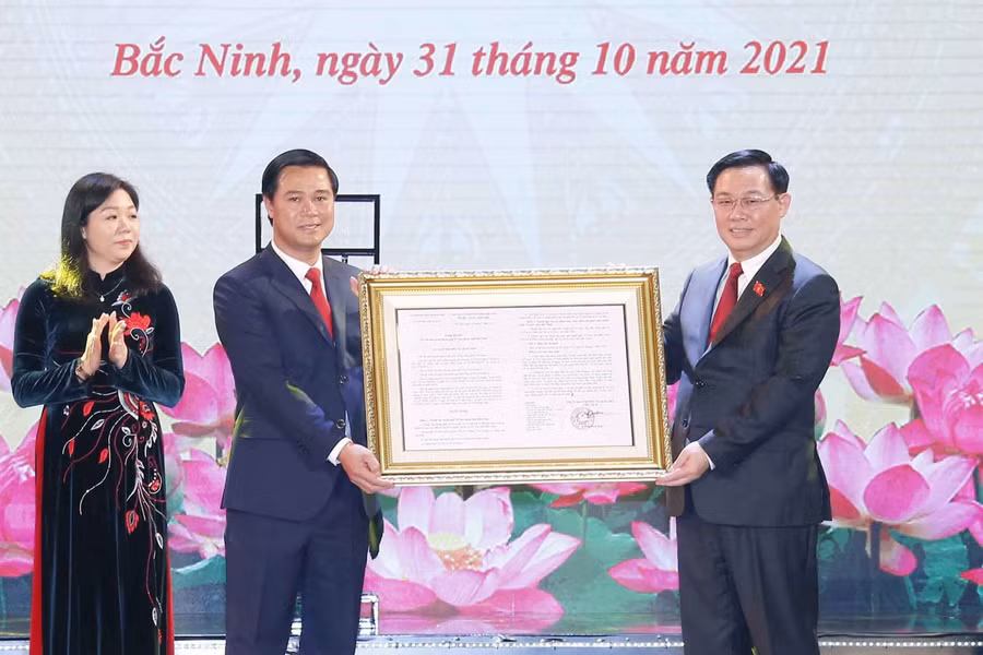 Chủ tịch Quốc hội Vương Đình Huệ đã trao Nghị quyết của Ủy ban Thường vụ Quốc hội cho lãnh đạo Thành phố Từ Sơn (Ảnh: TTXVN).
