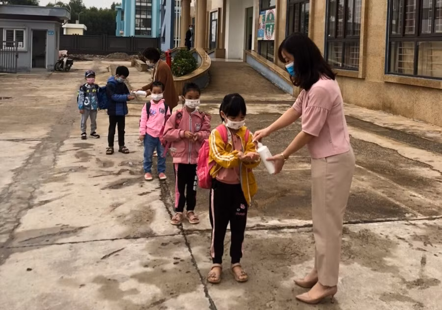 Học sinh trường Tiểu học Tân Tiến xếp hàng sát khuẩn tay trước khi vào lớp học.